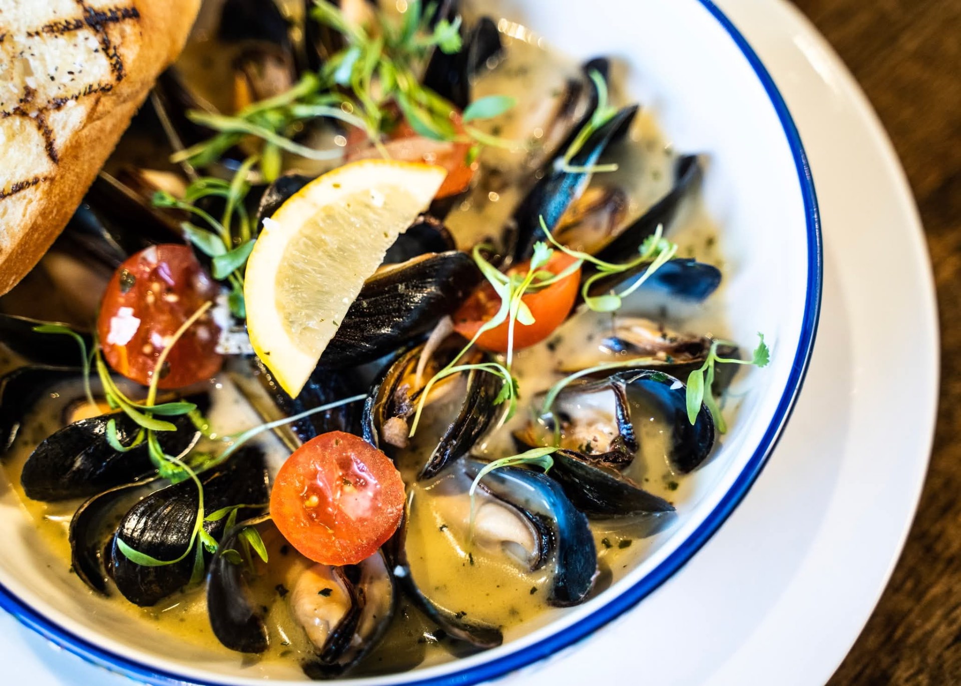 Mussels in white wine broth with blistered tomatoes and grilled bread at D'Vine Wine Bar