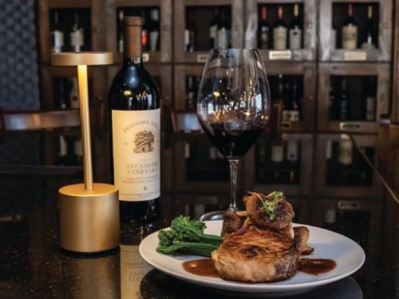 A bone-in chop, a glass of red and a bottle of Freemark Abbey in front of the wine lockers at D'Vine